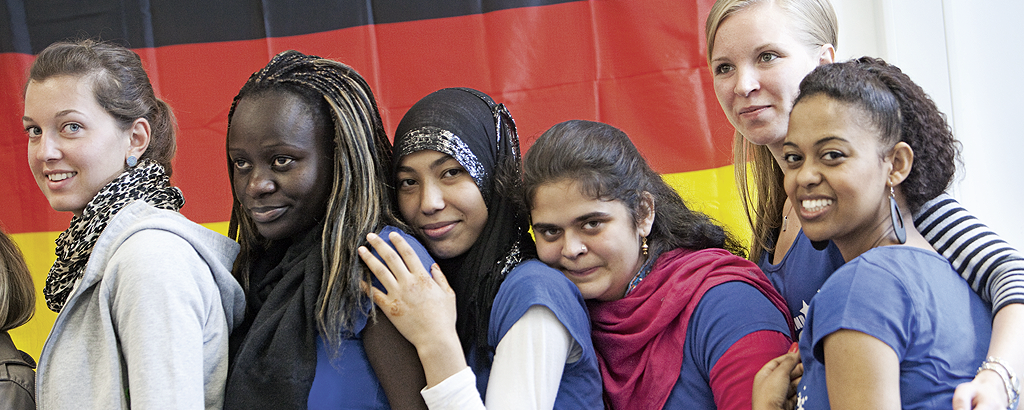 Junge Menschen vor einer Deutschland-Flagge.